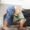 Little boy bending over in front of couch touching his toys.