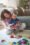 A mother and her young daughter sitting on a soft rug, engaging in playful learning with colorful wooden blocks, fostering creativity and connection.