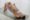 A smiling mother practices yoga on a mat while holding her baby on her stomach, engaging in a fun and bonding workout session.