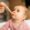 Young baby being fed pureed baby food on a spoon