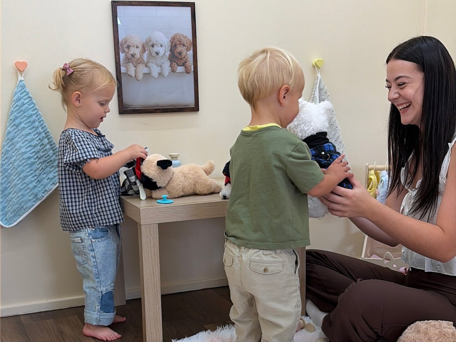 Toddlers caring for stuffed puppies at the pet station in the Baby University Play Village