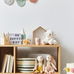 A cozy and organized playroom shelf featuring wooden toys, stuffed animals, and decorative elements, creating a warm and inviting space for children.